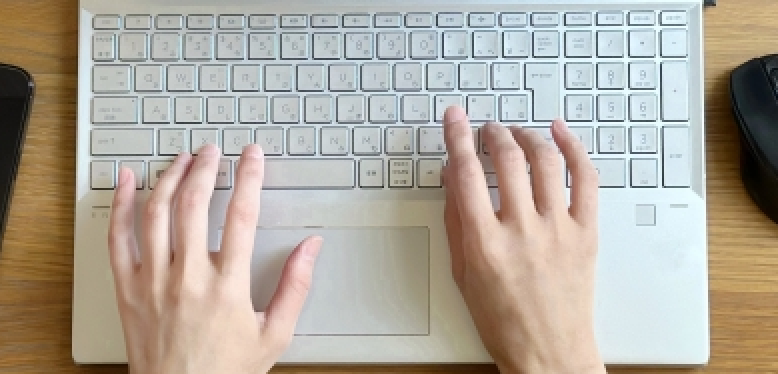 パソコンのキーボードを打ている様子