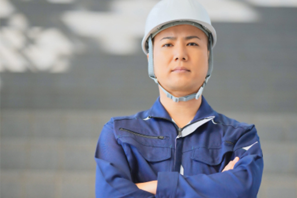 眉間に皺を寄せた作業服の男性